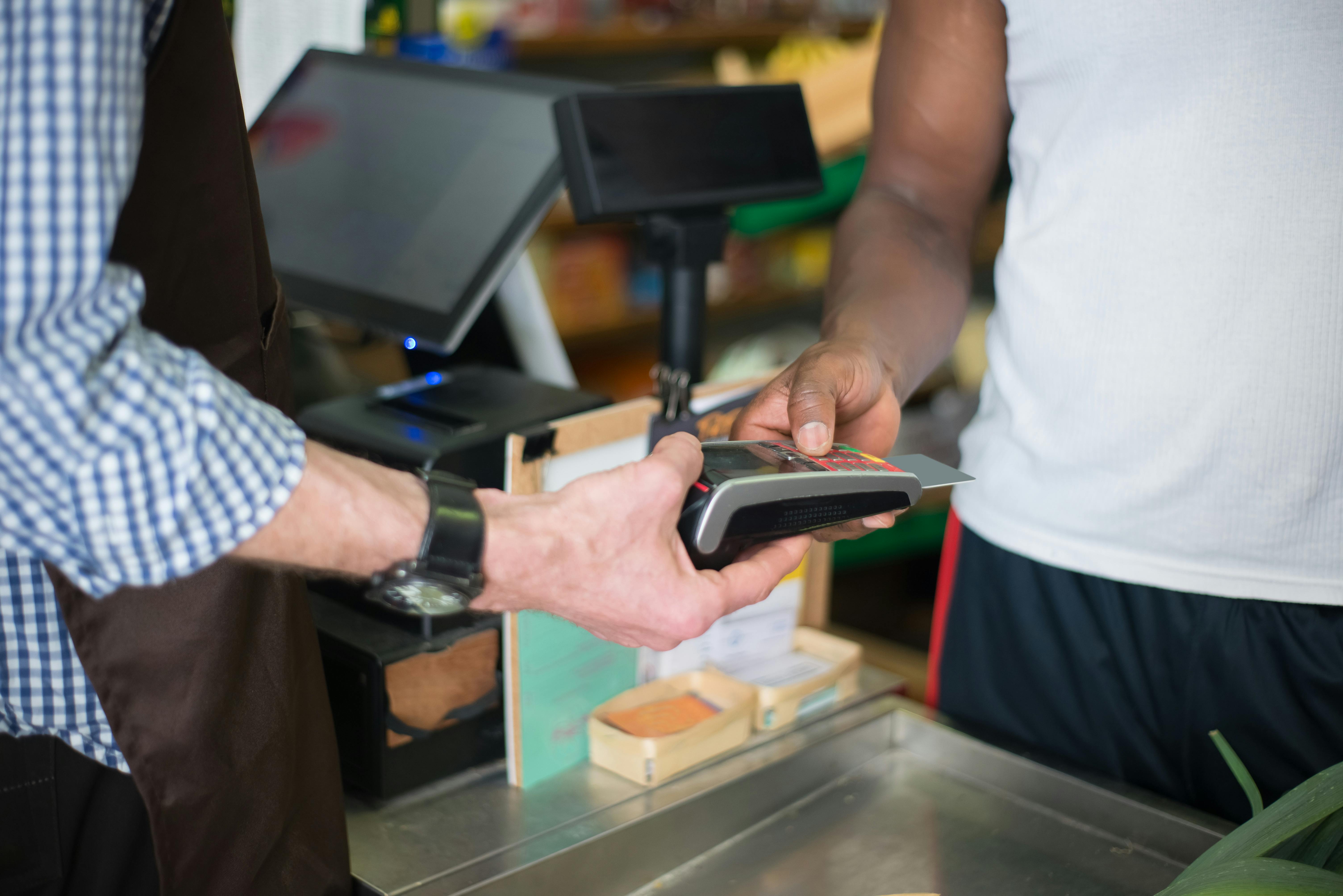 Cliente realizando pagamento no balcão com tecnologia moderna